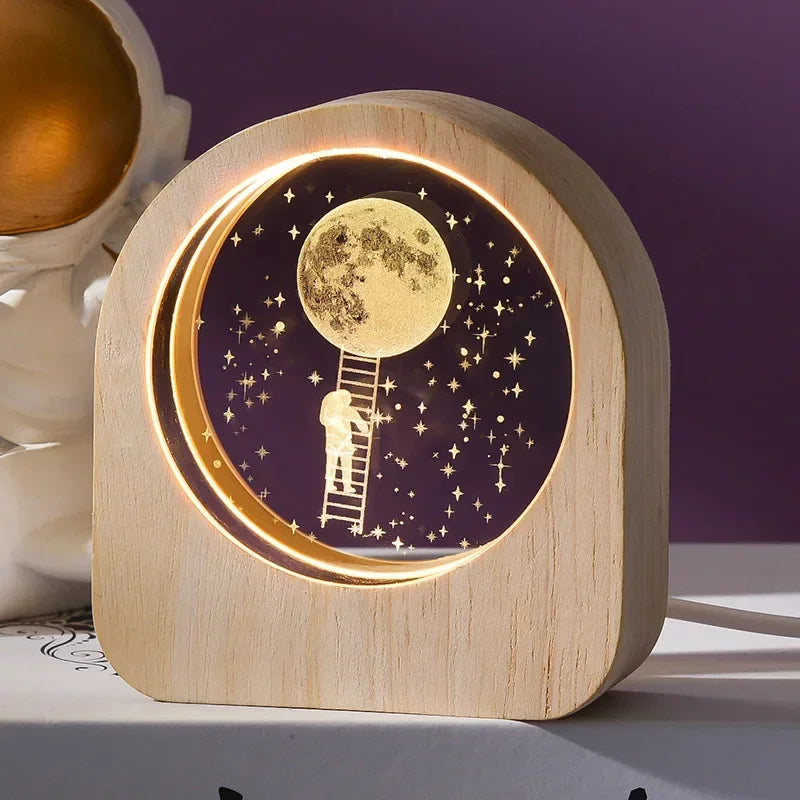 A 3D crystal laser engraved desk decor featuring an image of an astronaut climbing a ladder to the moon in an illuminated wooden frame.