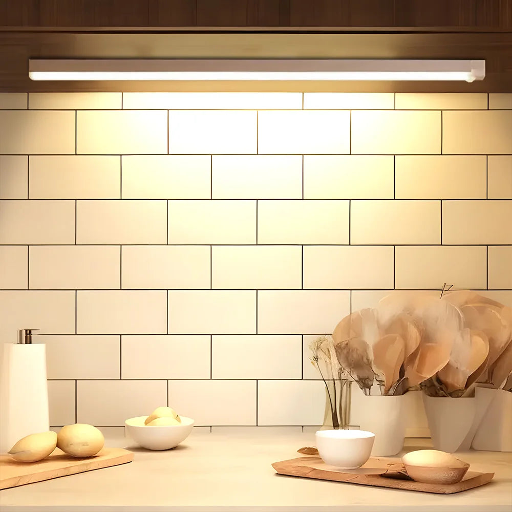 Two images showing a wireless LED motion sensor light bar with a white and warm white light, mounted on the wall under a shelf.